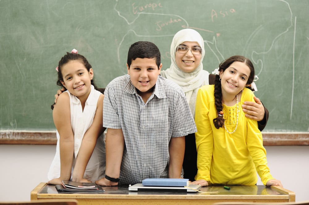 Students with and without disabilities work together in an inclusive classroom setting. Teacher provides specially designed instruction through small group activities while supporting peer collaboration and engagement.