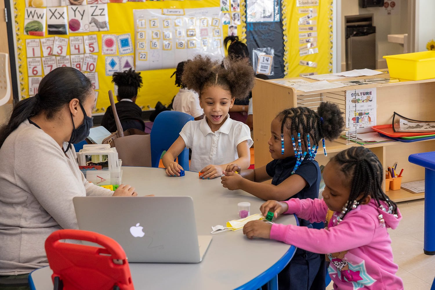 Photo of students sitting at a table with a teacher